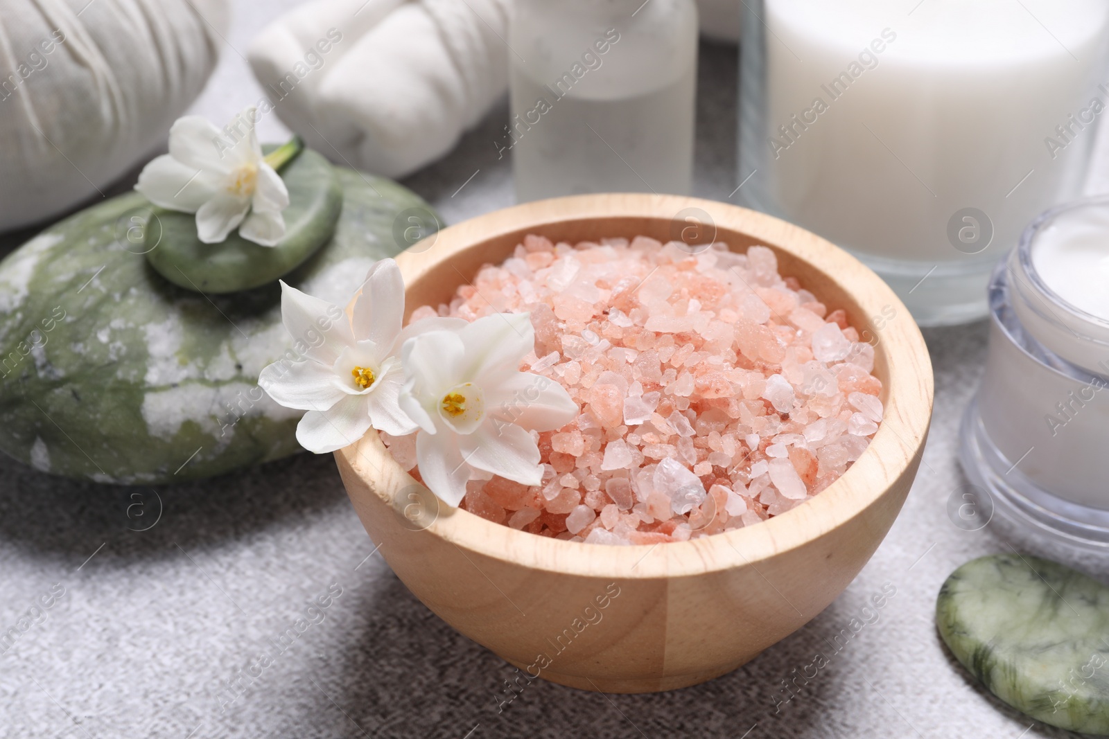 Photo of Spa composition with sea salt and flowers on light grey table