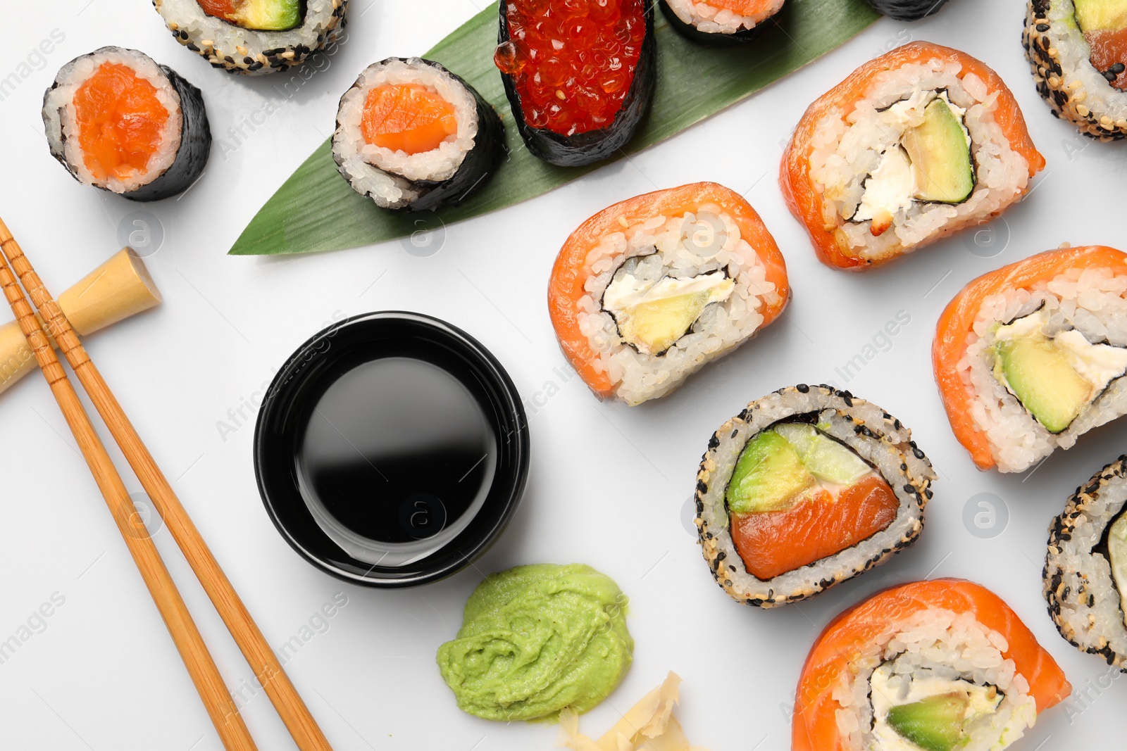 Photo of Set of delicious sushi rolls on white background, flat lay