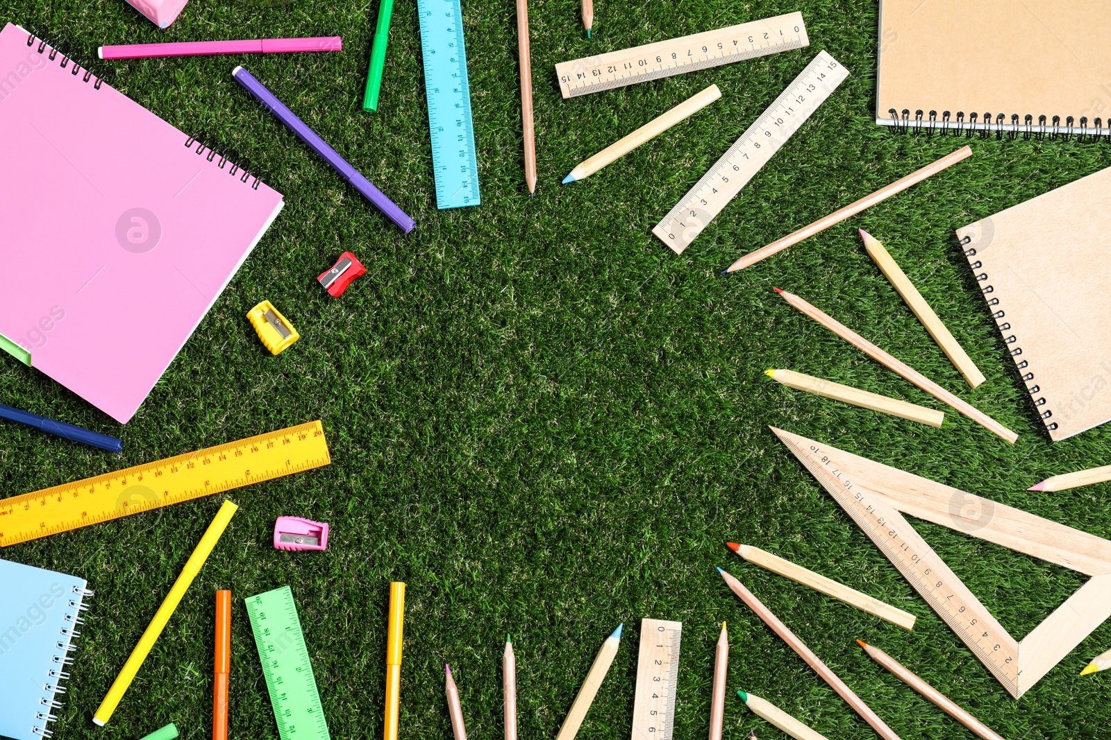 Photo of Flat lay composition with plastic and wooden stationery on green grass, space for text. Recycling concept