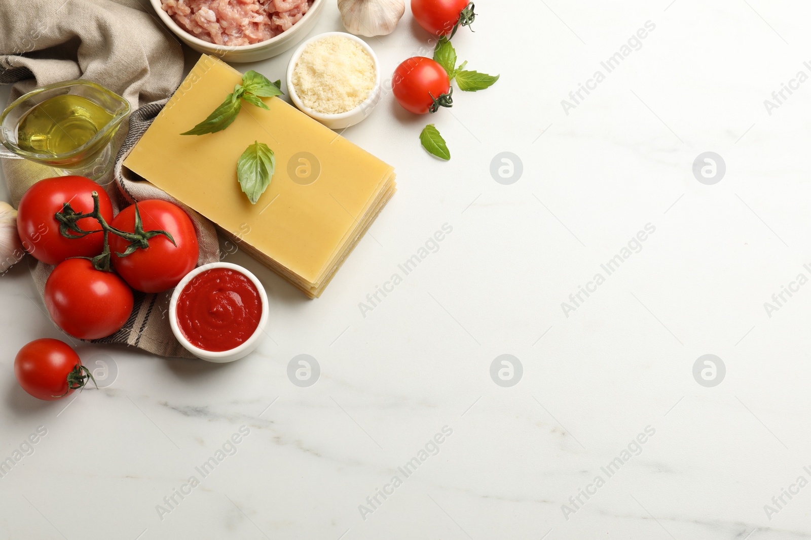 Photo of Ingredients for lasagna on white marble table, flat lay. Space for text