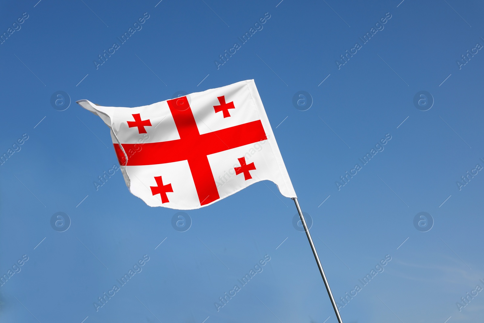 Image of National flag of Georgia against blue sky