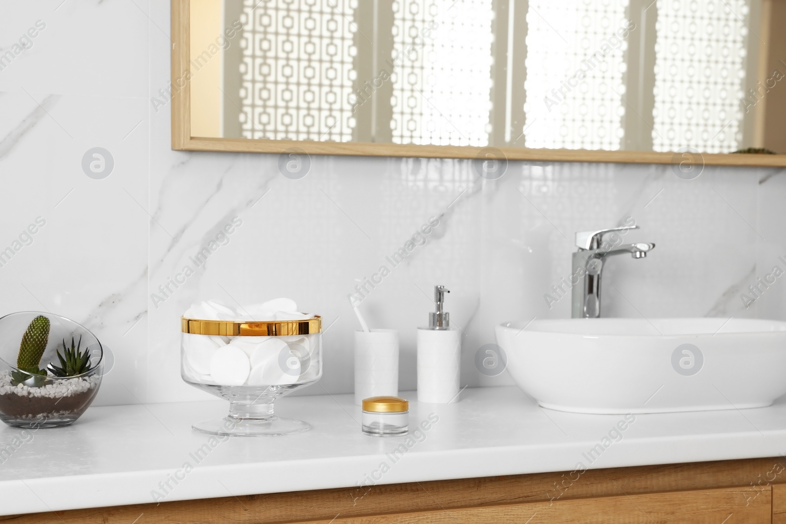 Photo of Jar with cotton pads on bathroom countertop