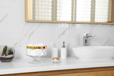 Photo of Jar with cotton pads on bathroom countertop