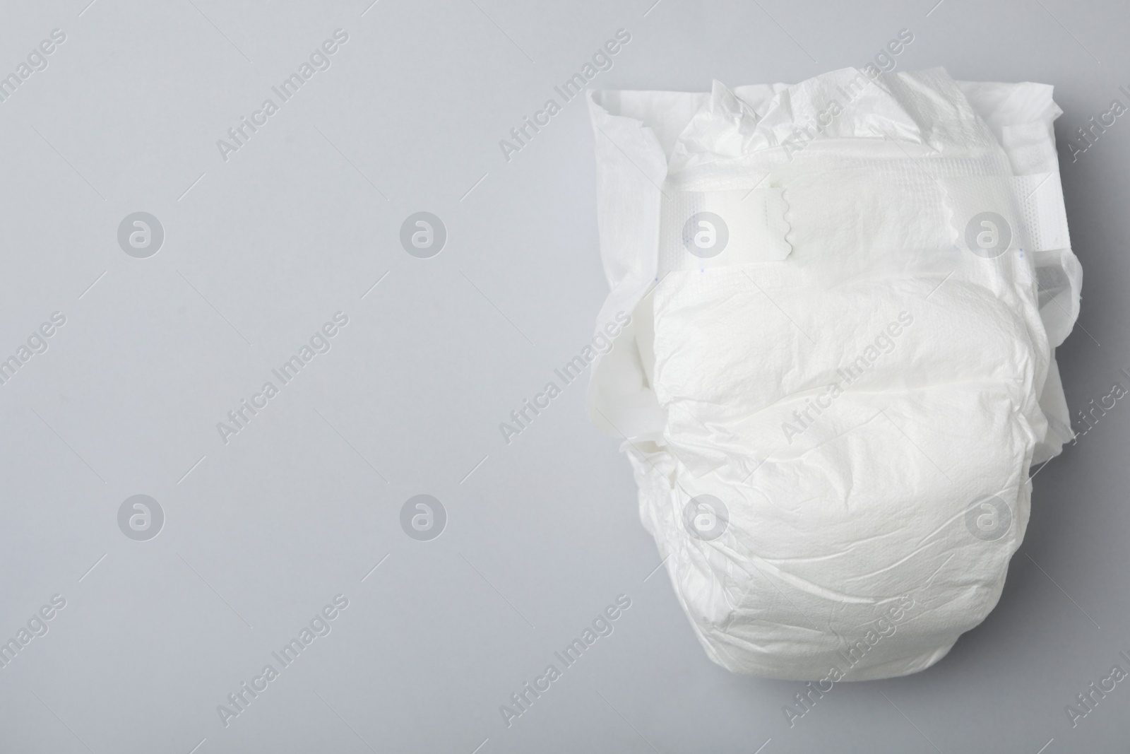 Photo of Baby diaper on light grey background, top view. Space for text