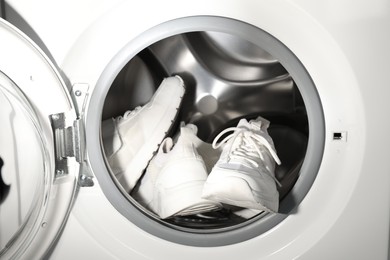 Stylish clean sneakers inside modern washing machine