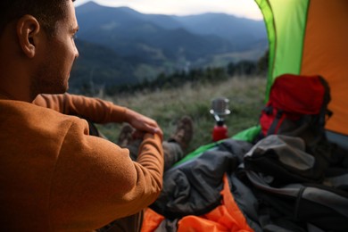 Photo of Man inside of camping tent in mountains
