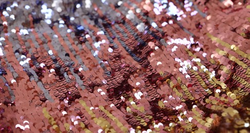 Photo of Texture of stylish pink carnival dress with sequins as background, closeup