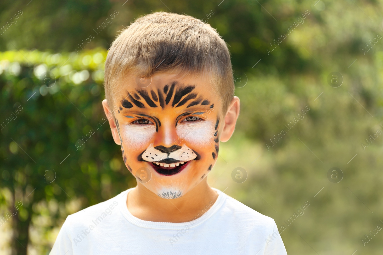 Photo of Cute little boy with face painting outdoors