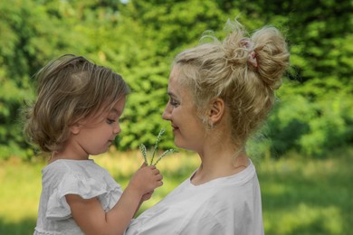 Photo of Beautiful mother with her cute daughter spending time together outdoors