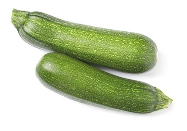 Raw ripe zucchinis on white background, top view