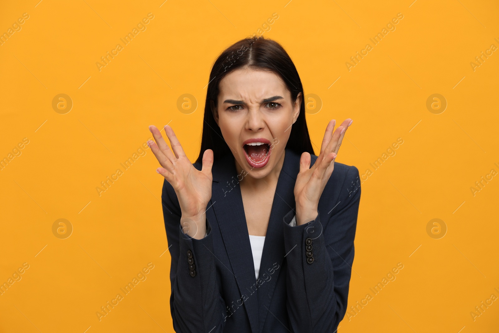Photo of Angry young woman on yellow background. Hate concept