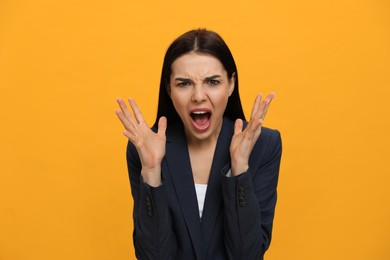 Photo of Angry young woman on yellow background. Hate concept