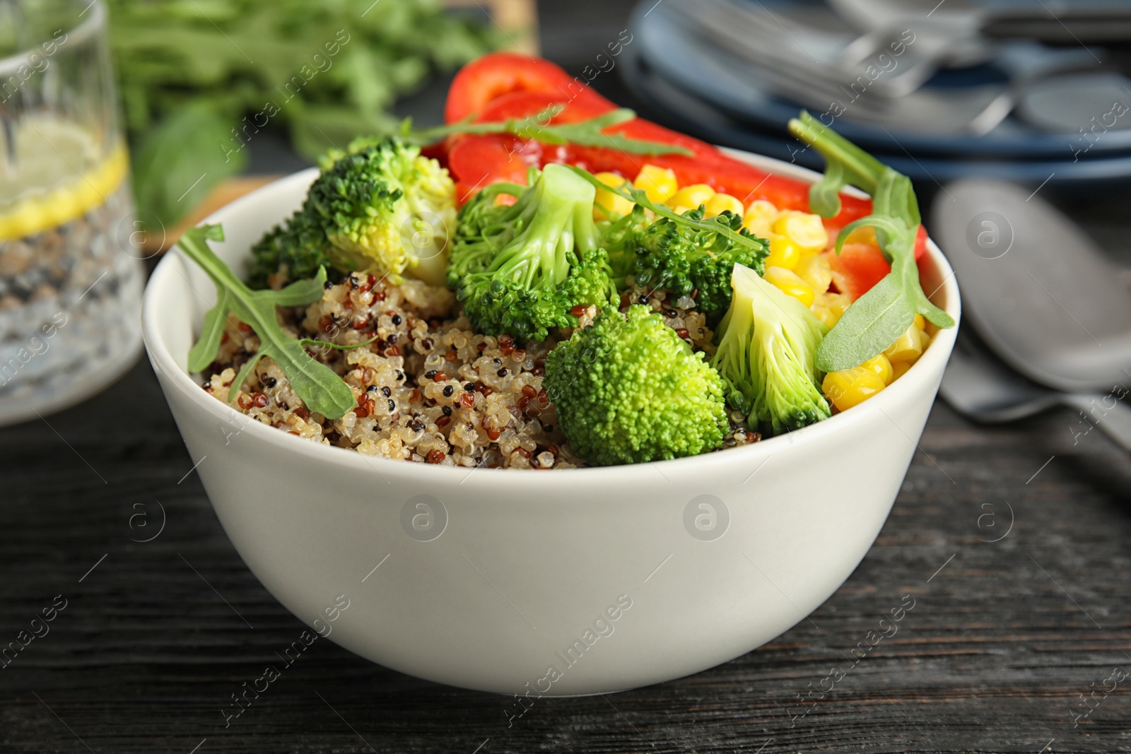 Photo of Bowl with quinoa and different vegetables on table, closeup