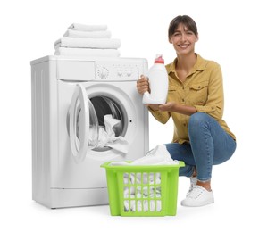 Beautiful woman with detergent near washing machine on white background