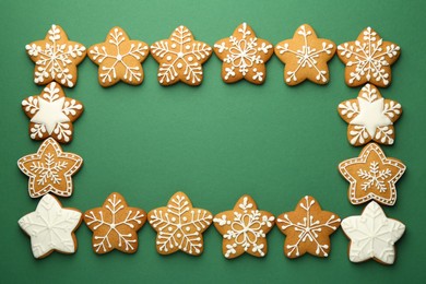 Photo of Frame made of tasty Christmas cookies with icing on green background, flat lay. Space for text