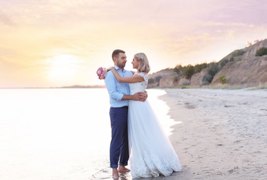 Photo of Wedding couple. Bride and groom standing on beach