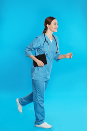 Photo of Doctor with clipboard and stethoscope running on blue background