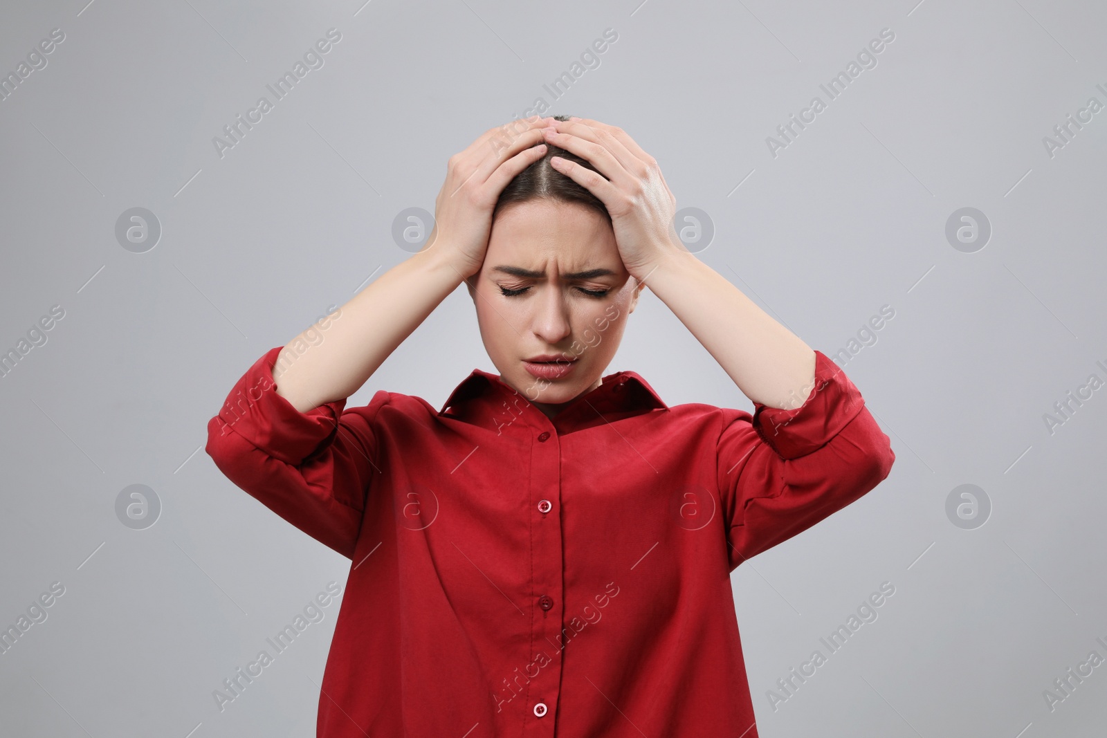 Photo of Woman suffering from headache on light grey background. Cold symptoms