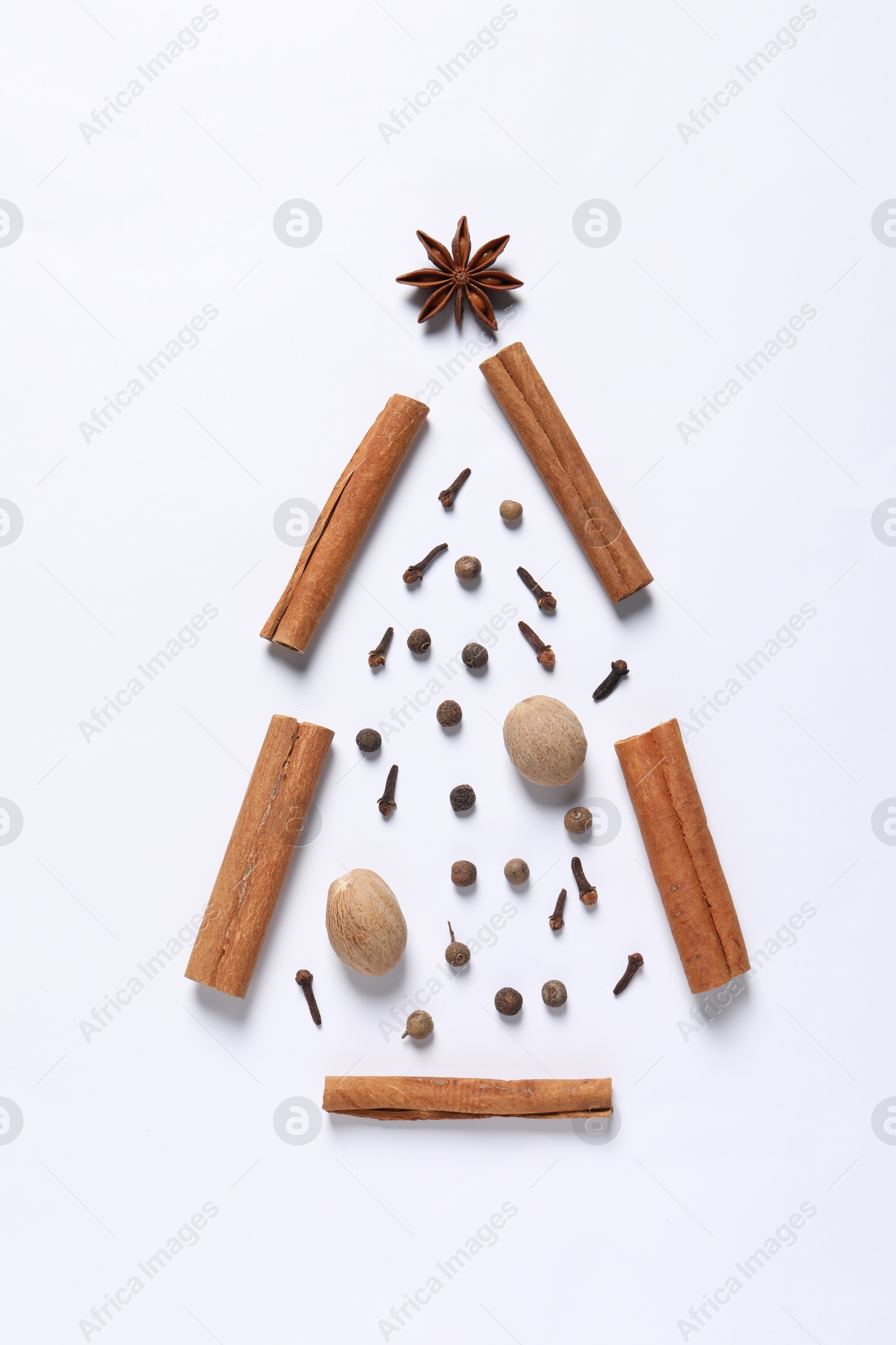 Photo of Christmas tree made of different spices on white table, flat lay