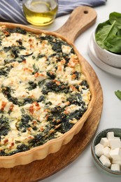 Delicious homemade spinach quiche on white table, closeup