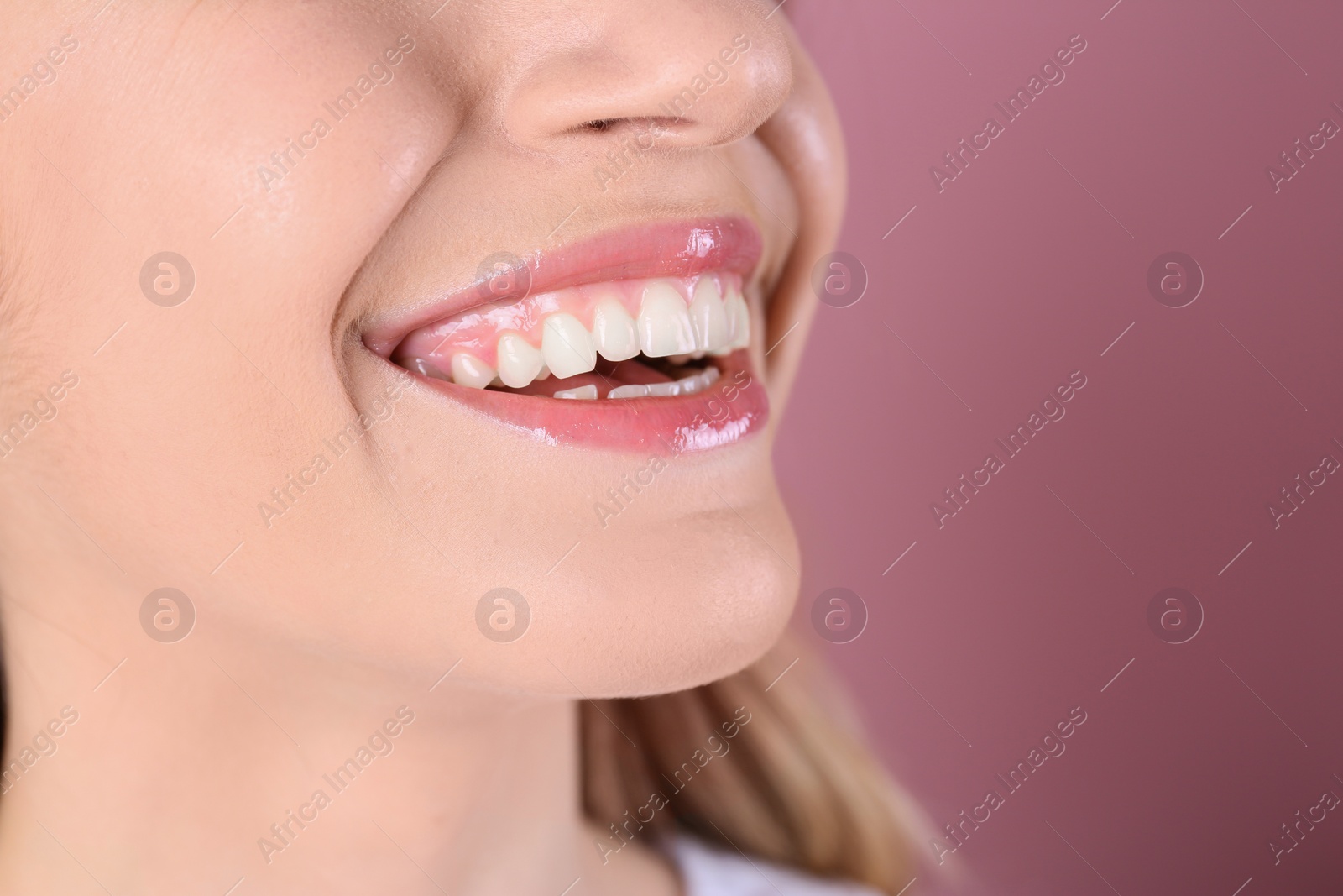 Photo of Young woman with healthy teeth and beautiful smile on color background, closeup. Space for text