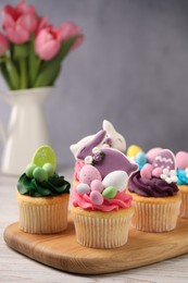 Photo of Tasty decorated Easter cupcakes on wooden table