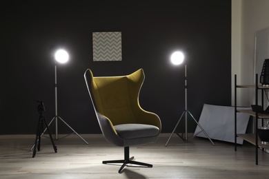 Interior of modern photo studio with armchair and professional equipment