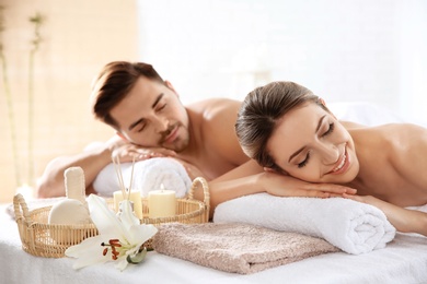 Photo of Young couple with spa essentials in wellness center