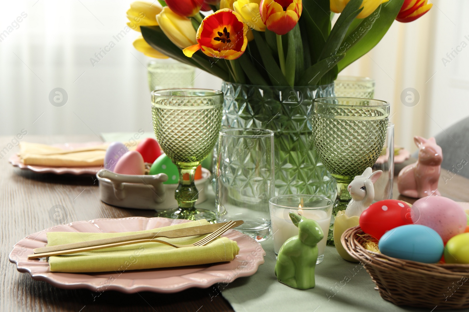 Photo of Easter celebration. Festive table setting with beautiful flowers and painted eggs