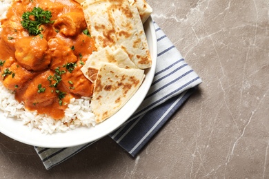 Photo of Delicious butter chicken with rice served on table, top view. Space for text