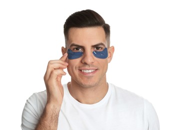 Photo of Man applying blue under eye patch on white background
