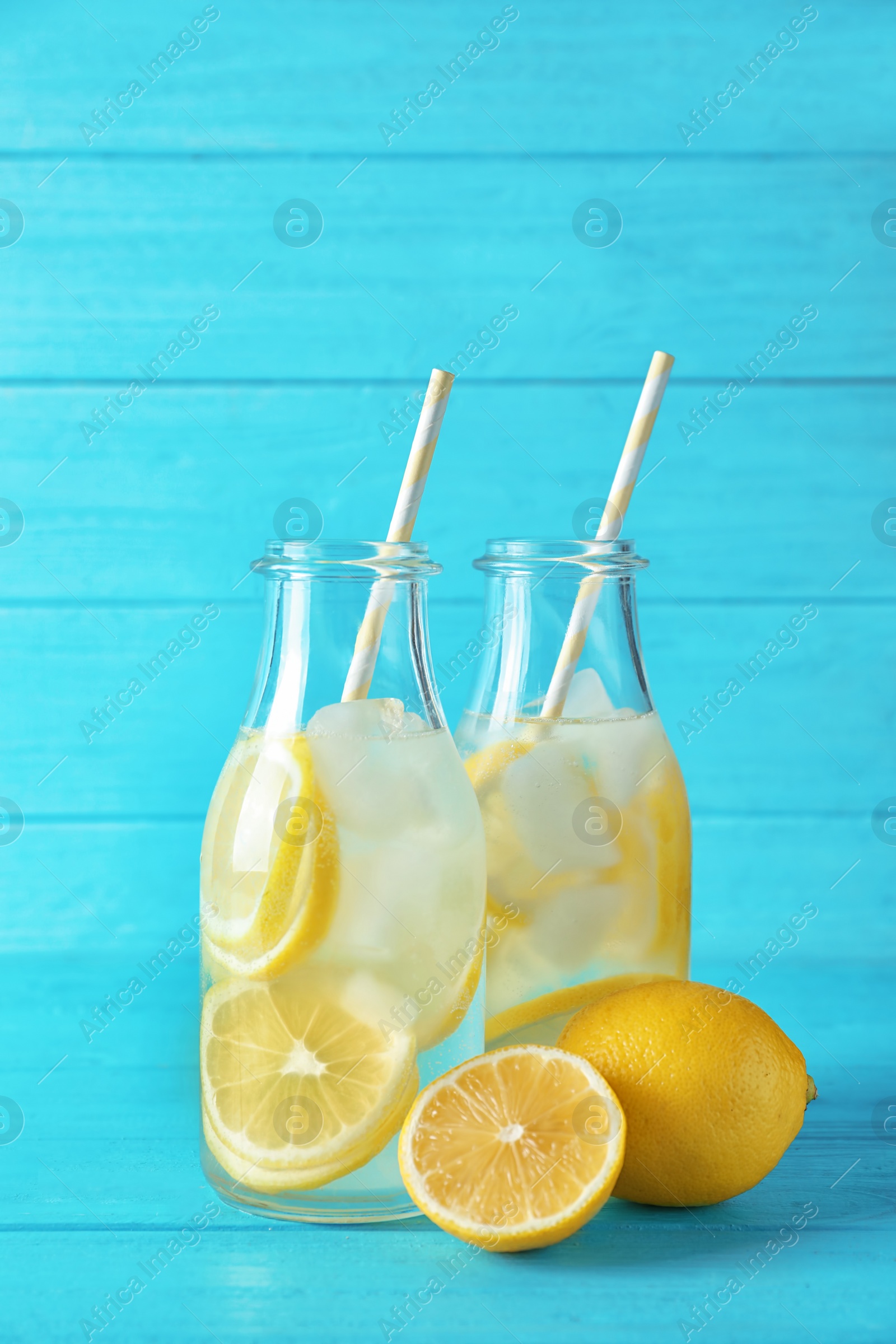 Photo of Natural lemonade in bottles on wooden table