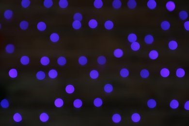 Blurred view of blue Christmas lights on dark background