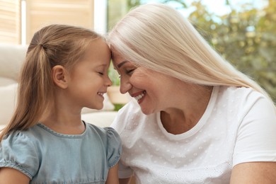 Photo of Happy grandmother spending time with her granddaughter at home