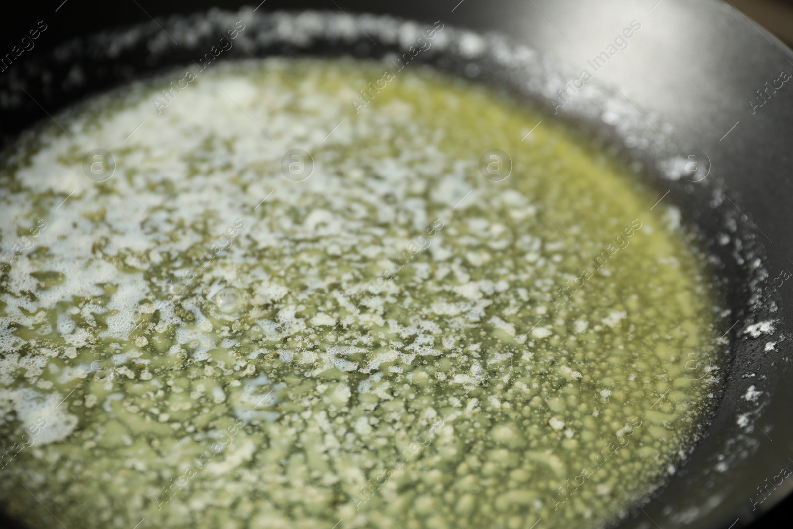 Photo of Melting butter in frying pan, closeup view