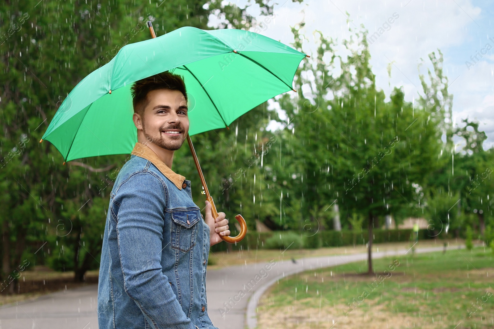 Photo of Man with umbrella outdoors on rainy day