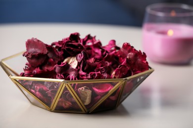 Aromatic potpourri of dried flowers in glass bowl on table indoors, closeup