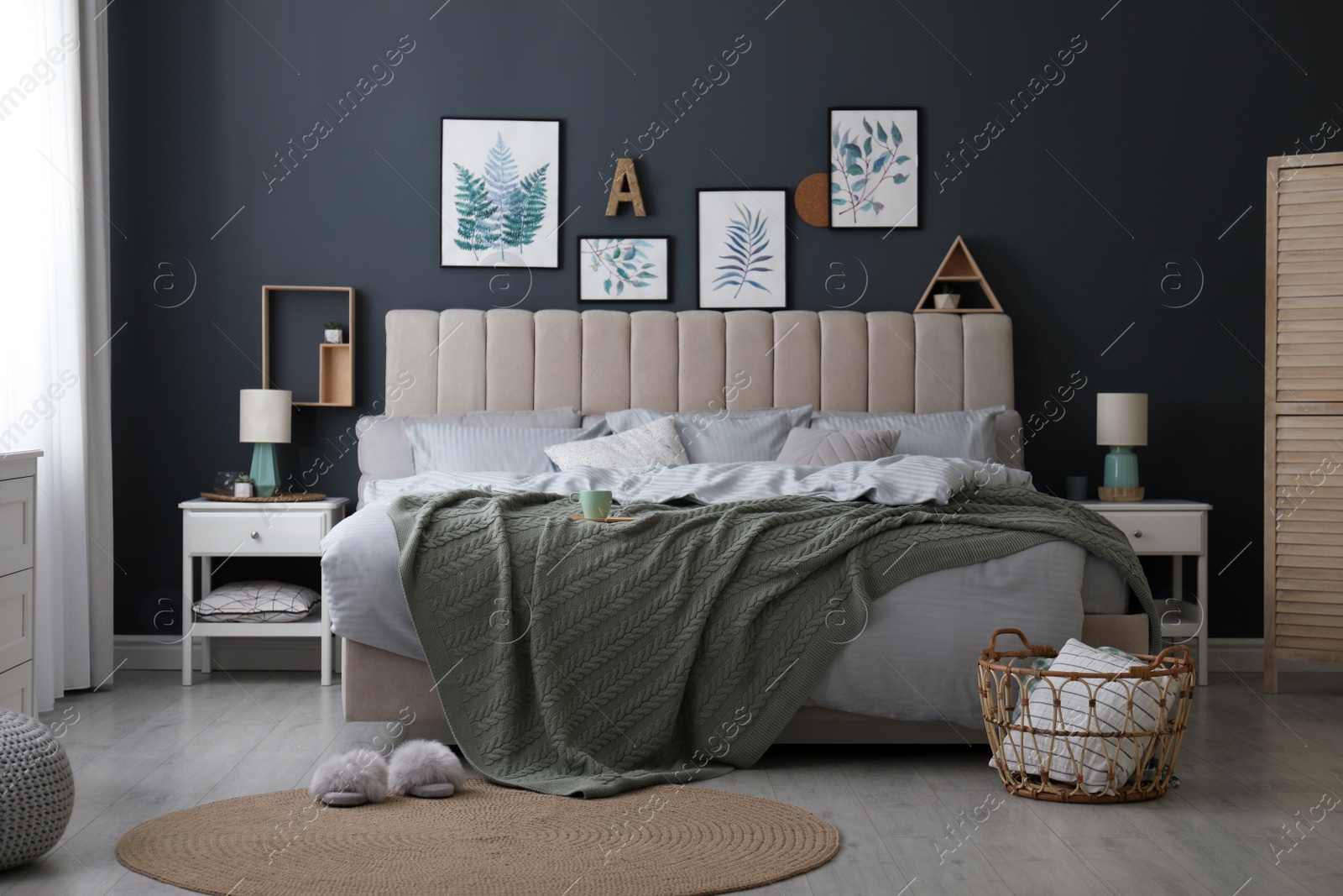 Photo of Comfortable bed with knitted green plaid in stylish room interior