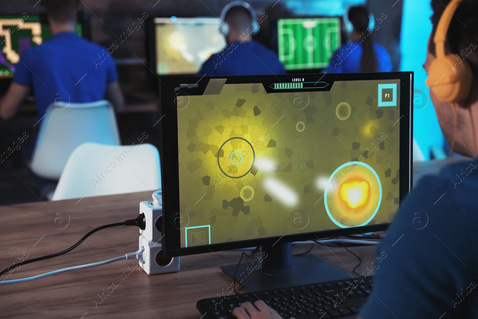 Photo of Man playing video game in internet cafe