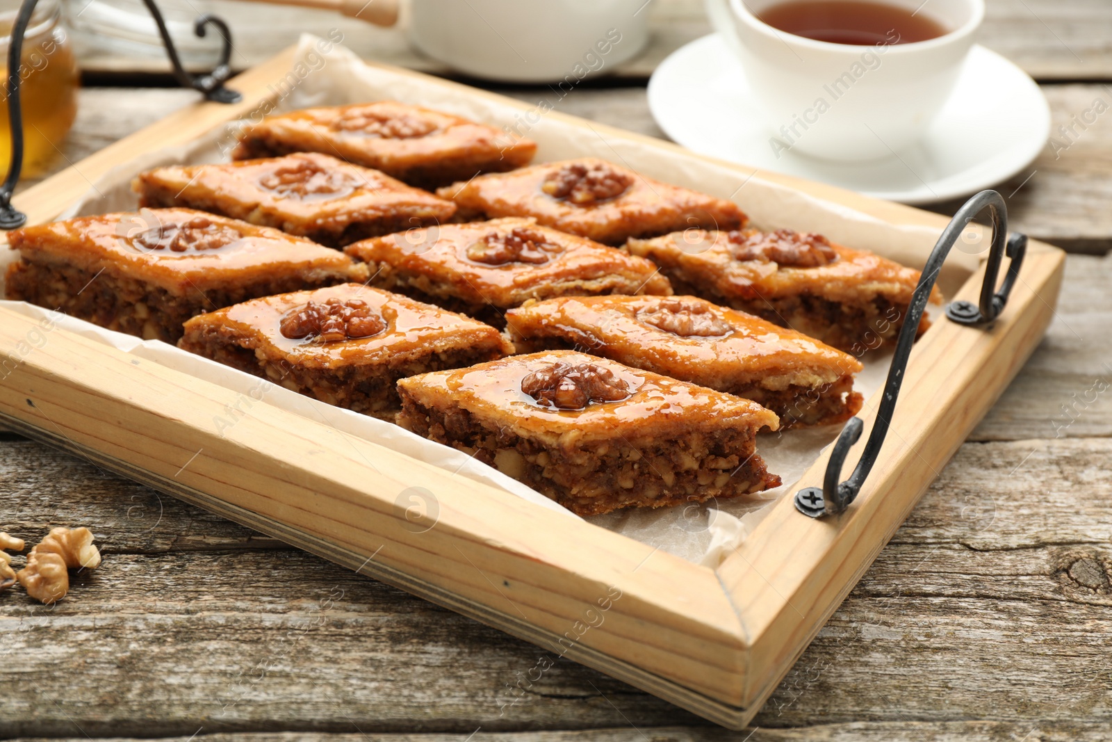 Photo of Delicious sweet baklava with walnuts on wooden table, closeup