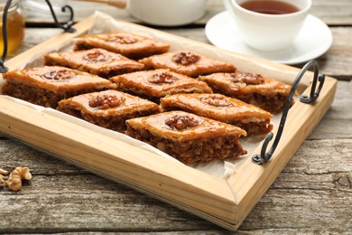 Delicious sweet baklava with walnuts on wooden table, closeup