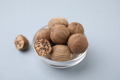 Photo of Nutmegs in glass bowl on white background