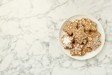 Photo of Tasty star shaped Christmas cookies with icing on white marble table, top view. Space for text