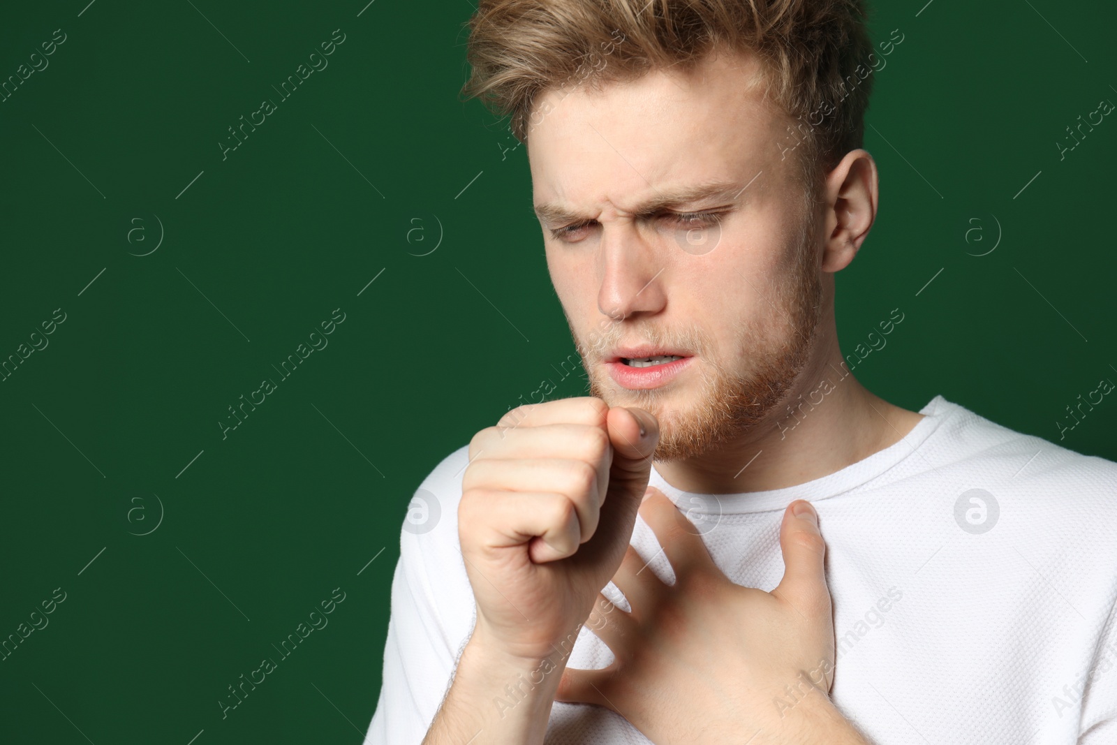 Photo of Handsome young man coughing against color background. Space for text