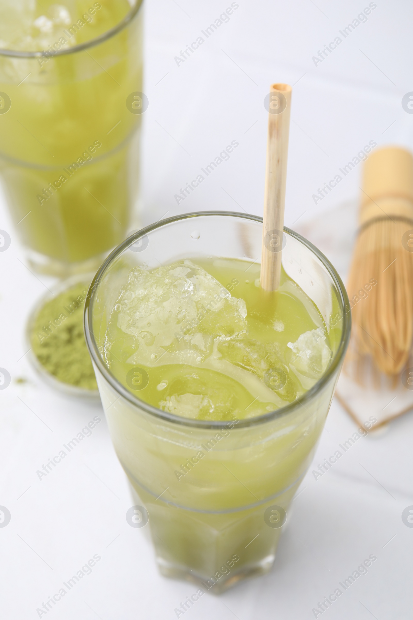 Photo of Glass of delicious iced green matcha tea on white table, above view