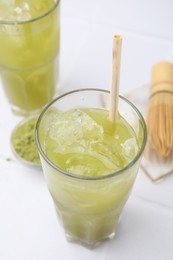 Photo of Glass of delicious iced green matcha tea on white table, above view