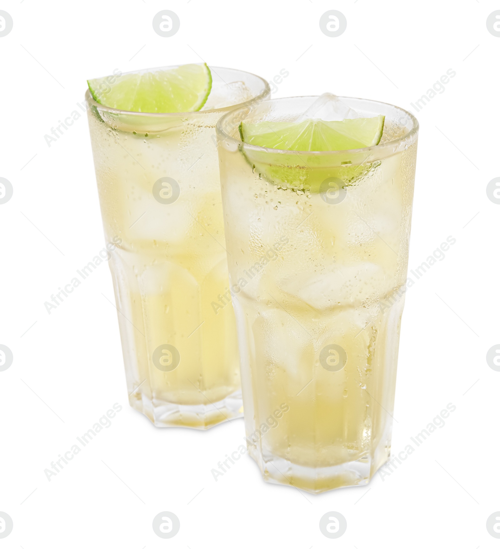 Photo of Glasses of tasty ginger ale with ice cubes and lime slices isolated on white