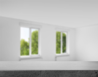 Empty grey stone surface and blurred view of modern windows 