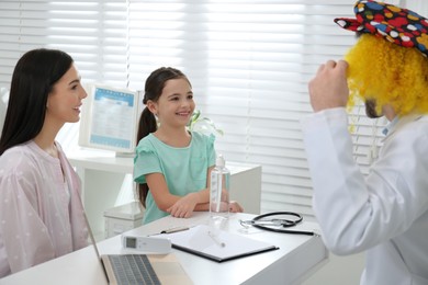 Mother with daughter visiting funny pediatrician in hospital