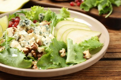 Fresh salad with pear on wooden table